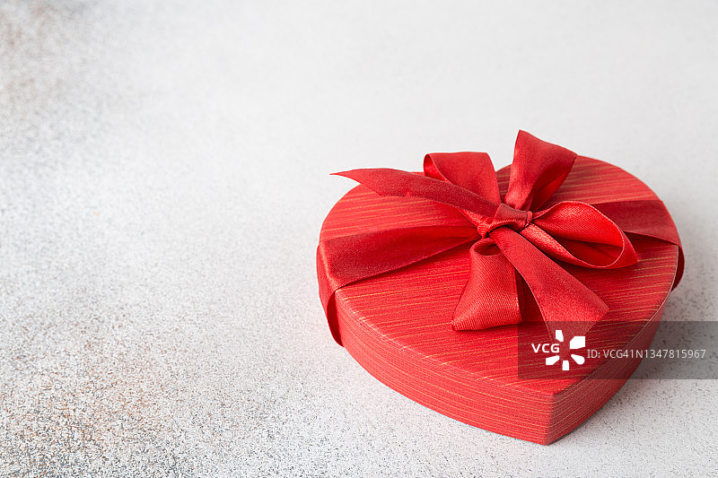 浅色背景上的红色心形蝴蝶结礼品盒图片素材