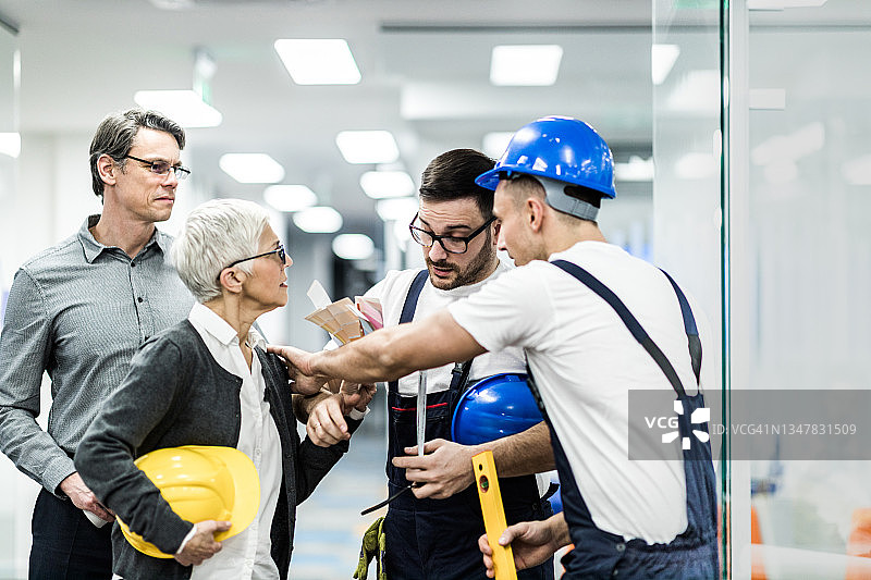 办公楼走廊工人与建筑师争执图片素材