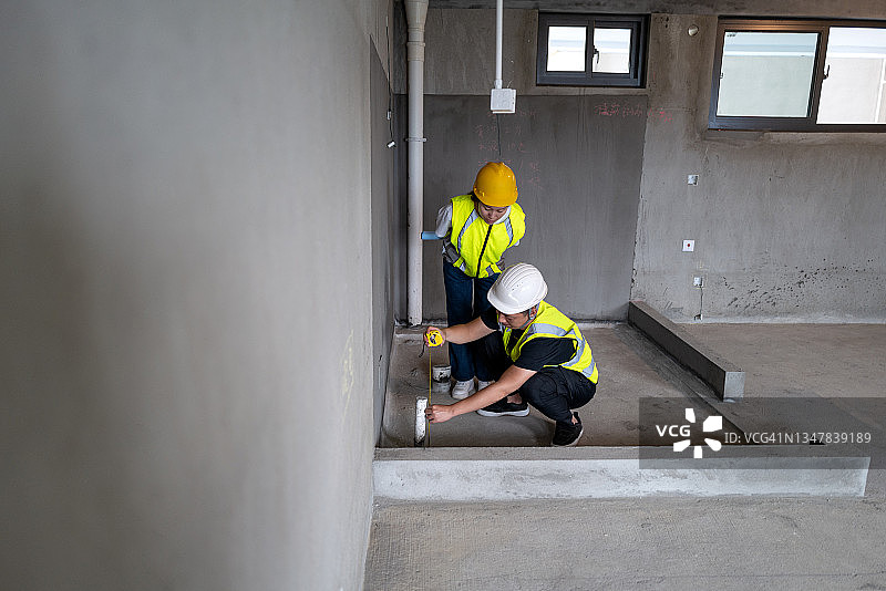 在新房子里工作的年轻亚洲男女工程师图片素材