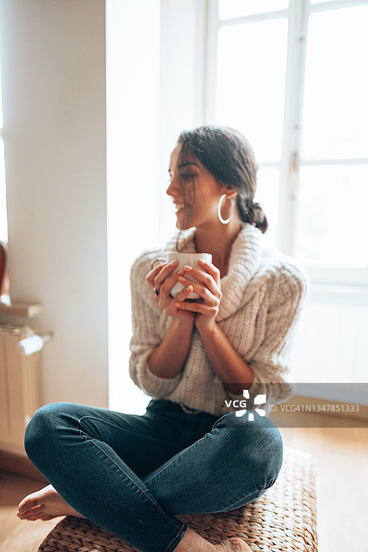 在沙发上喝热茶的漂亮女人图片素材