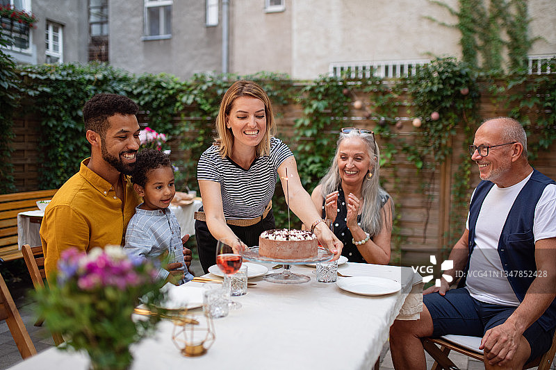 多种族三代同堂家庭在院子里庆祝生日的合影图片素材