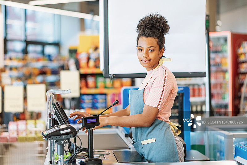 在超市收银台工作的非洲员工，面带微笑图片素材