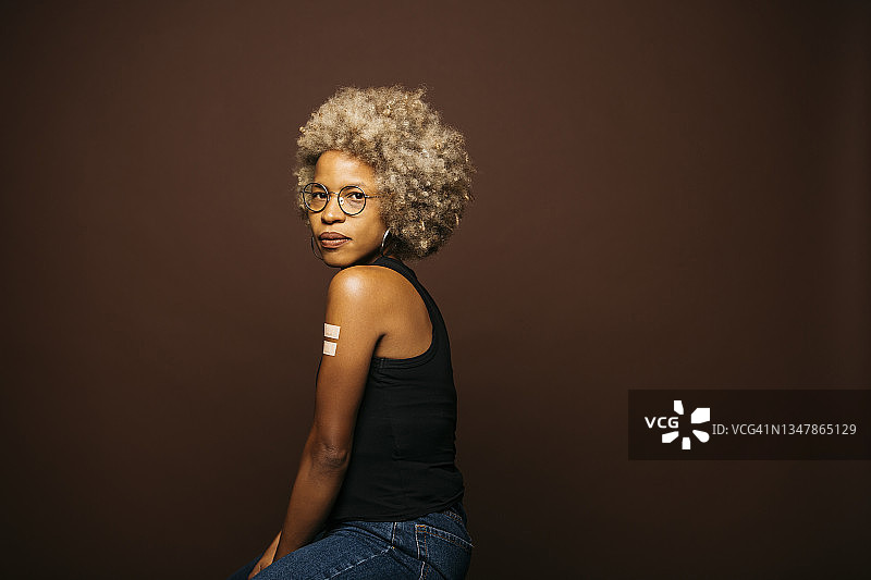 接种疫苗后贴着创可贴的女人图片素材