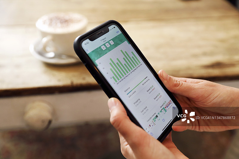 一名女子正在看手机银行App图片素材