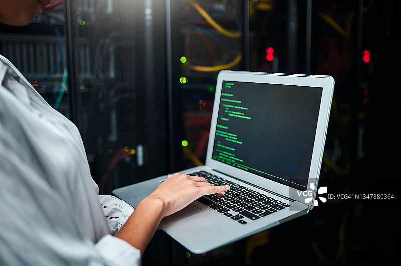 在服务器机房使用笔记本电脑的匿名女子特写图片素材