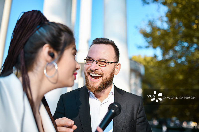 男政客在接受女记者采访时讲笑话图片素材