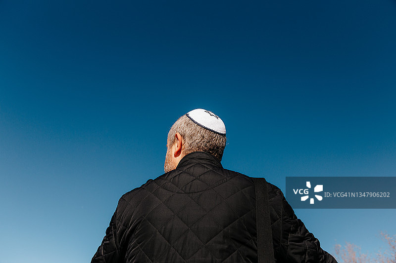 犹太男子的后视图，戴着小圆帽，望着蓝天图片素材