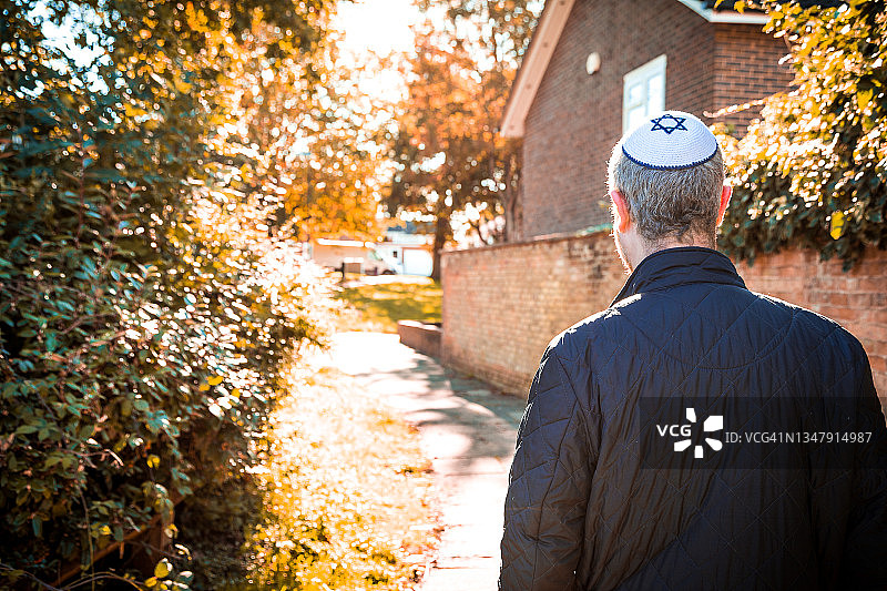 戴小帽走在住宅街道上的犹太男人图片素材