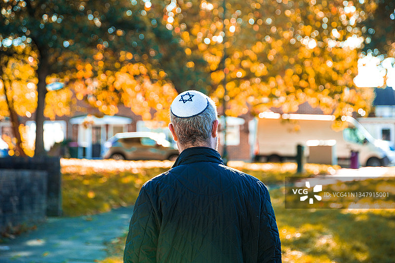 戴小帽走在住宅街道上的犹太男人图片素材
