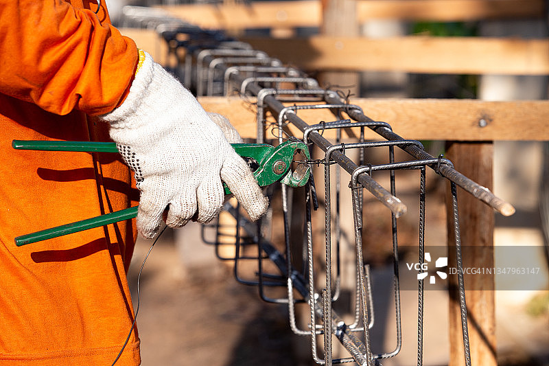 蓝领工人将钢筋绑在混凝土柱上图片素材