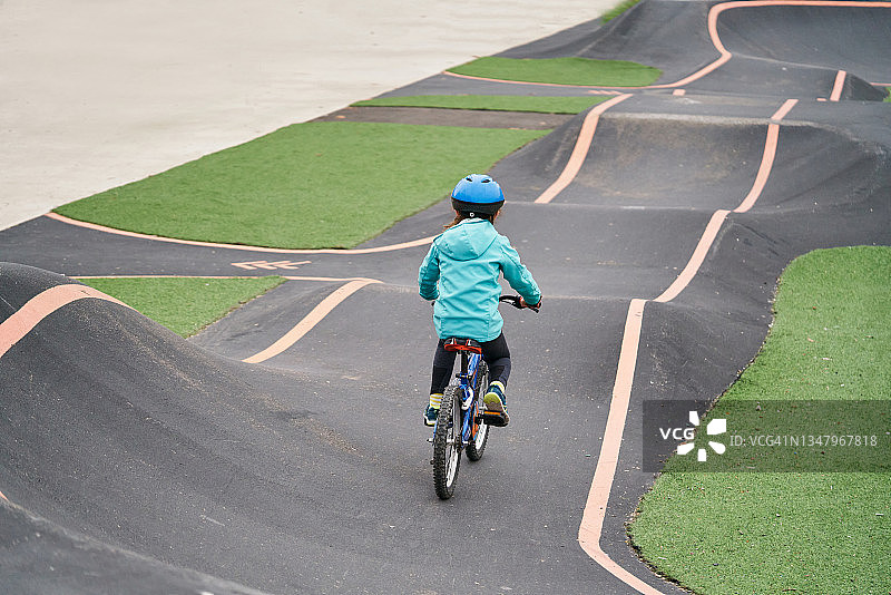 小女孩在水泥泵道上骑自行车图片素材