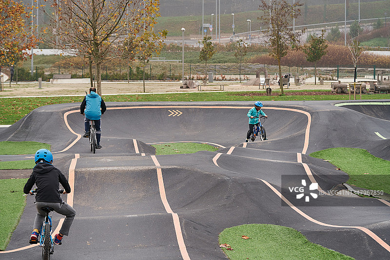 孩子们在水泥泵道上骑自行车图片素材