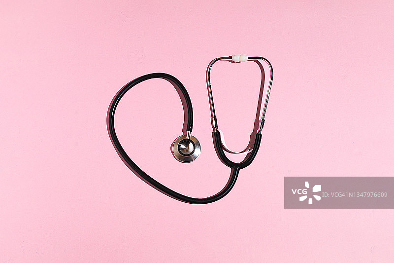 粉色背景上的黑色听诊器图片素材