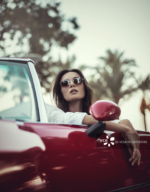 年轻女人在敞篷老爷车里享受户外时光图片素材