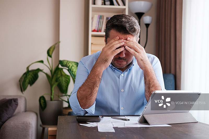 男人在家计算个人支出图片素材