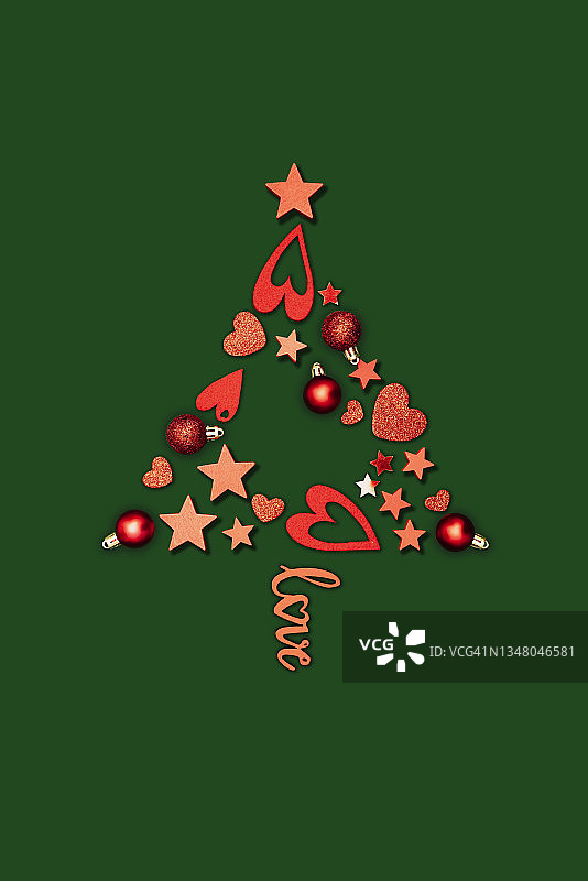红色圣诞装饰品，以圣诞树的形状摆放，绿色背景图片素材