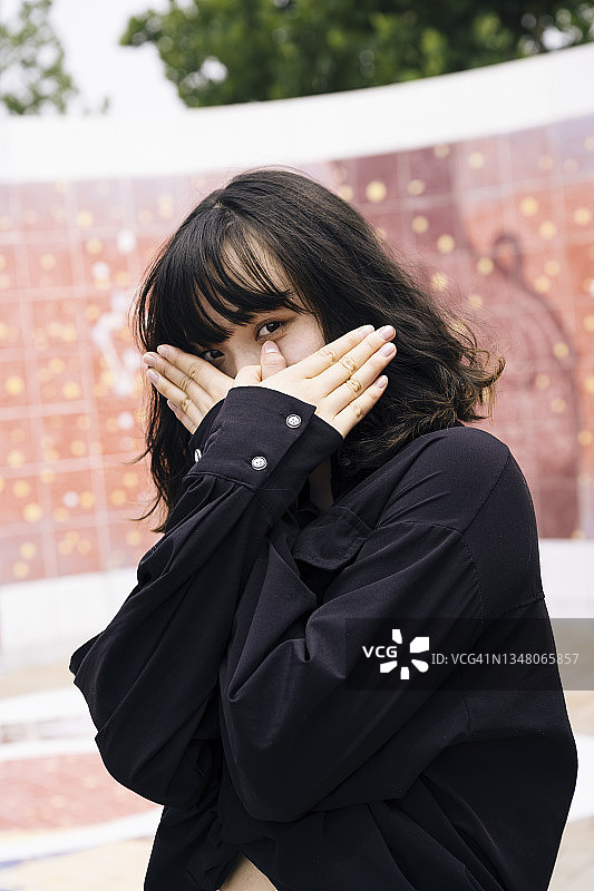 在成都清晨拍照的，面带期待的年轻亚洲女人图片素材