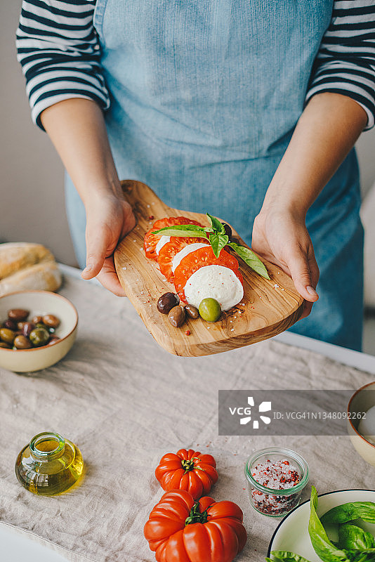 女人烹饪卡普雷塞沙拉图片素材