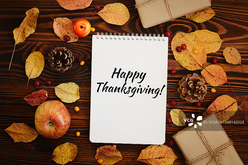感恩节贺卡，棕色桌子与苹果、秋树、松果、礼品盒图片素材
