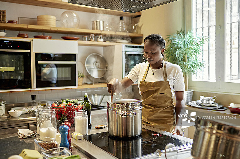 烹饪课上搅拌锅的年轻非洲学生图片素材