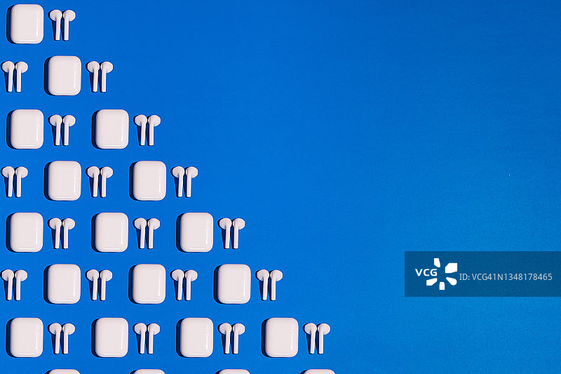 蓝色背景左侧的无线白色耳机图案及文案空间图片素材