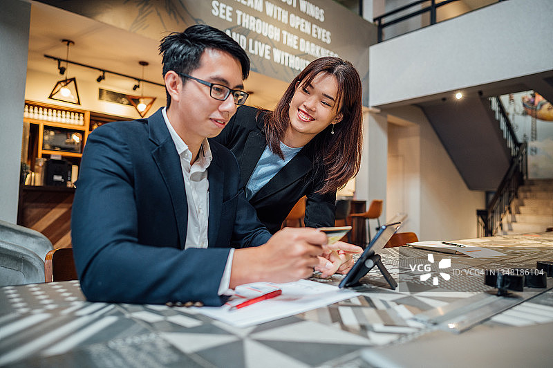 在办公室工作并使用信用卡的同事图片素材