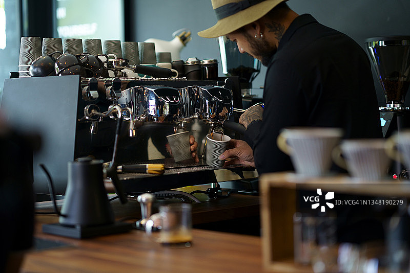 咖啡师将浓缩咖啡萃取到纸杯中图片素材