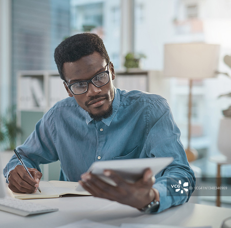 年轻商人现代办公室办公桌前使用平板电脑图片素材