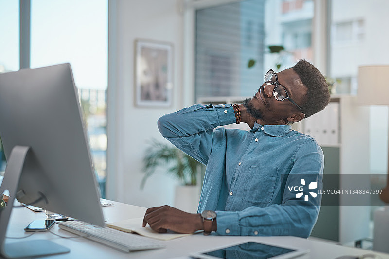 年轻商人现代办公室办公桌前使用电脑，面露焦虑图片素材