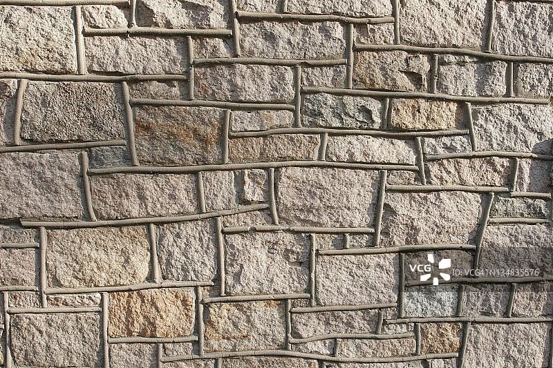 带有混凝土管道的棕褐色岩石墙图片素材