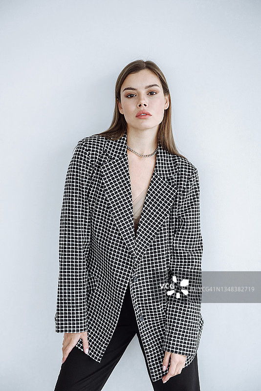 白色背景工作室，身穿模特夹克的性感黑发女子肖像图片素材