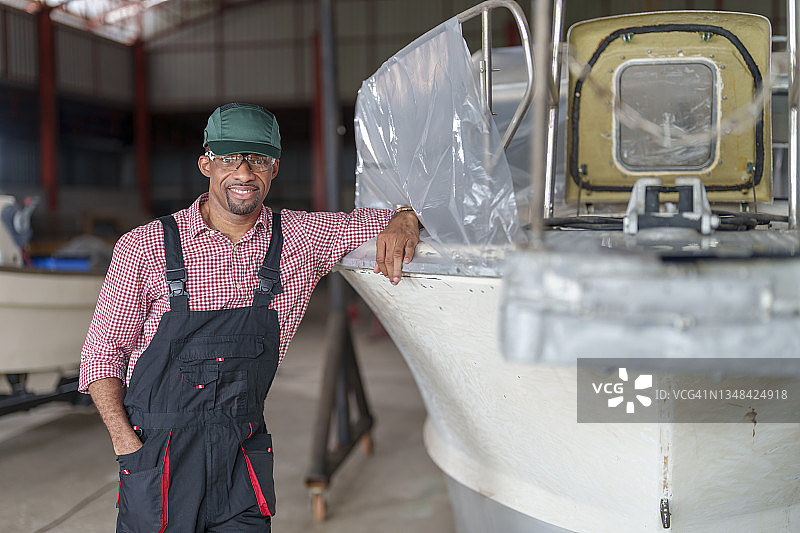 非洲裔轮机修理工在车间船边的服务肖像图片素材