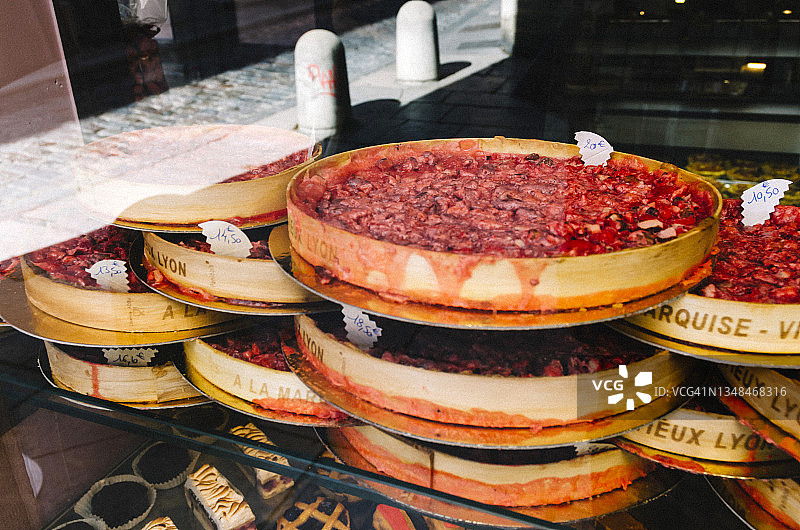 法国里昂面包店橱窗里的粉色果仁馅饼图片素材