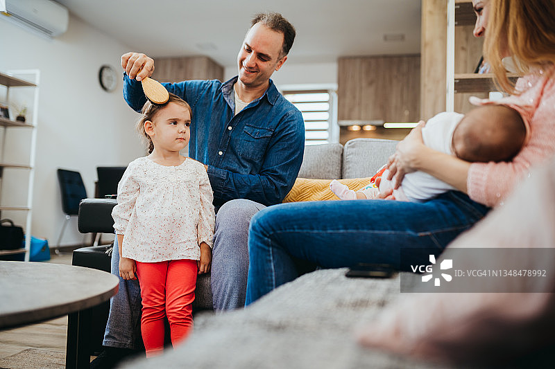 快乐的父亲为女儿梳头发图片素材