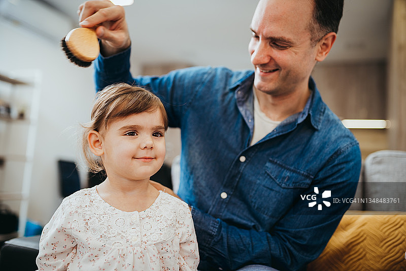 快乐的父亲为女儿梳头发图片素材