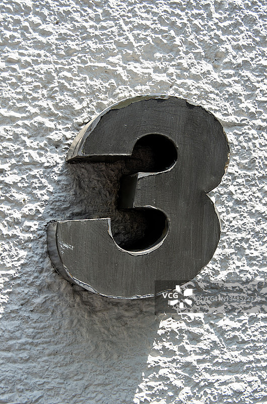 白色水泥墙上的不锈钢3D数字3图片素材