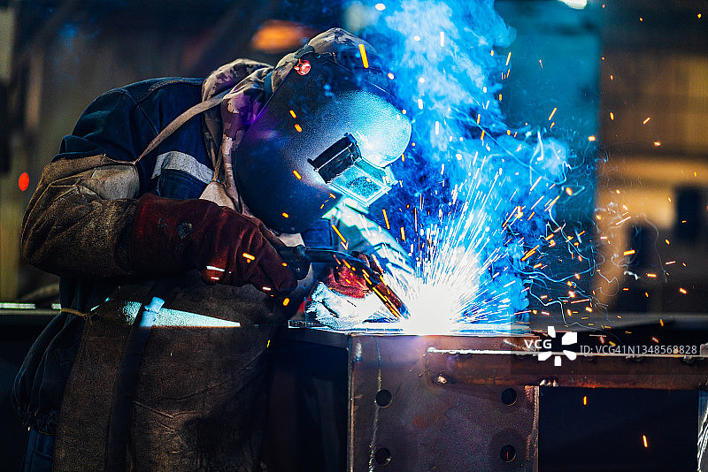 在大厅焊接金属型材的工业焊工图片素材