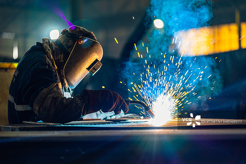 在大厅焊接金属型材的工业焊工图片素材