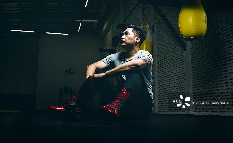 亚洲青年拳击手在拳击比赛失败后感到消极和悲伤，并向前看图片素材