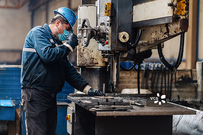 在机修车间操作传统非数控铣床的机械师图片素材