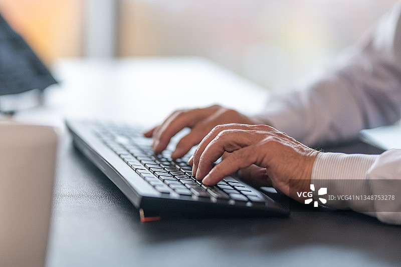 男性在办公室键盘上打字特写图片素材