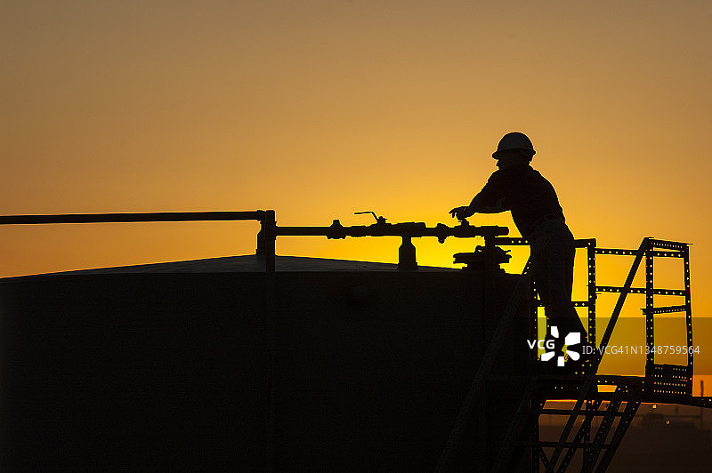 储罐上的油田工人轮廓图片素材