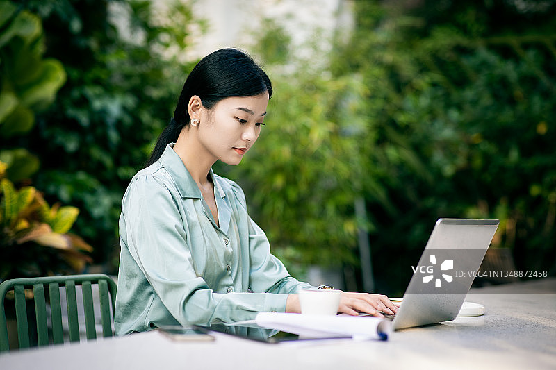 年轻女商人在咖啡馆使用笔记本电脑工作图片素材