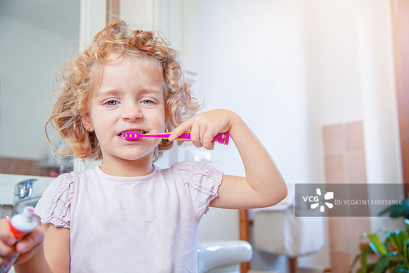 在浴室里刷牙的金发五岁女孩图片素材