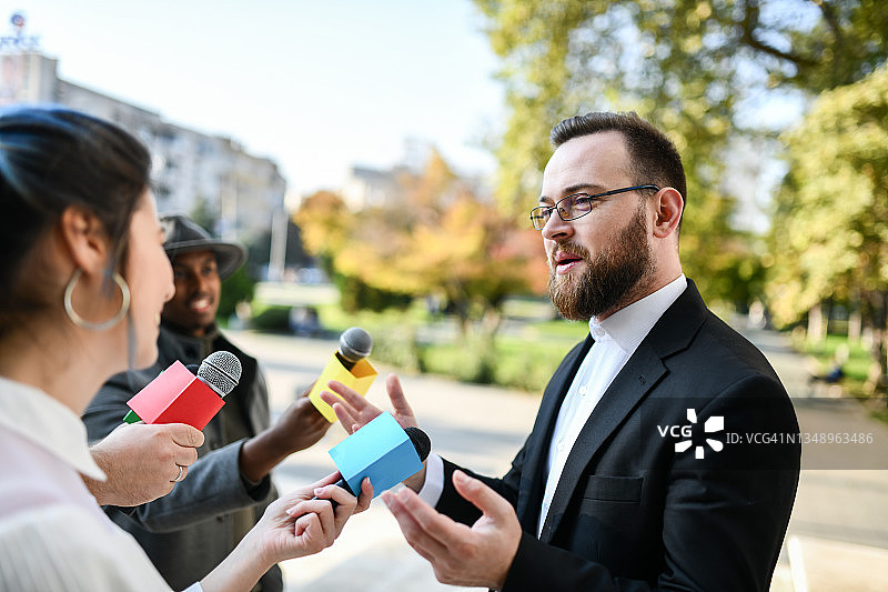 微笑成功的男政治家在户外的新闻发布会进展顺利图片素材