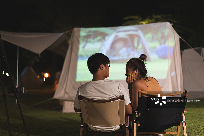 年轻情侣在露营地观看电影图片素材