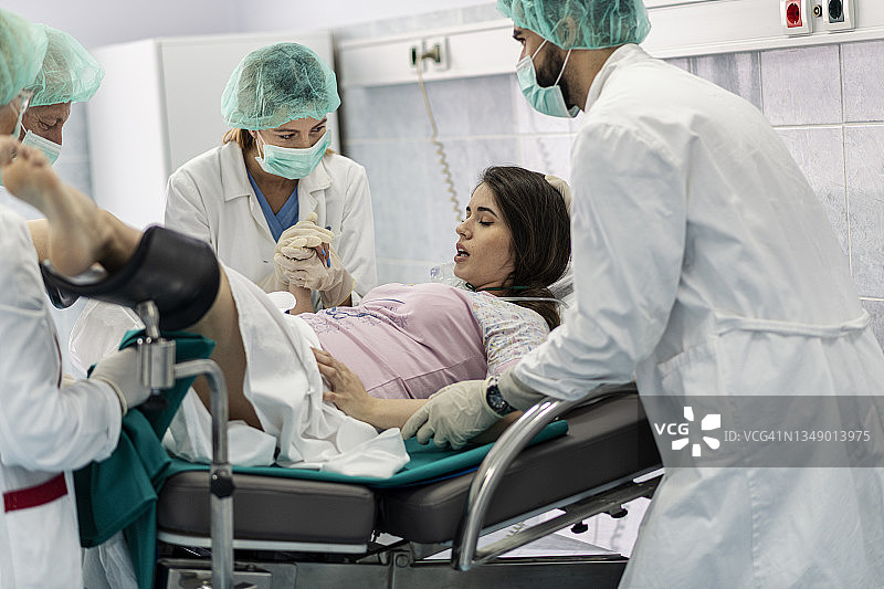 妇产科医生协助医院里的妇女分娩图片素材