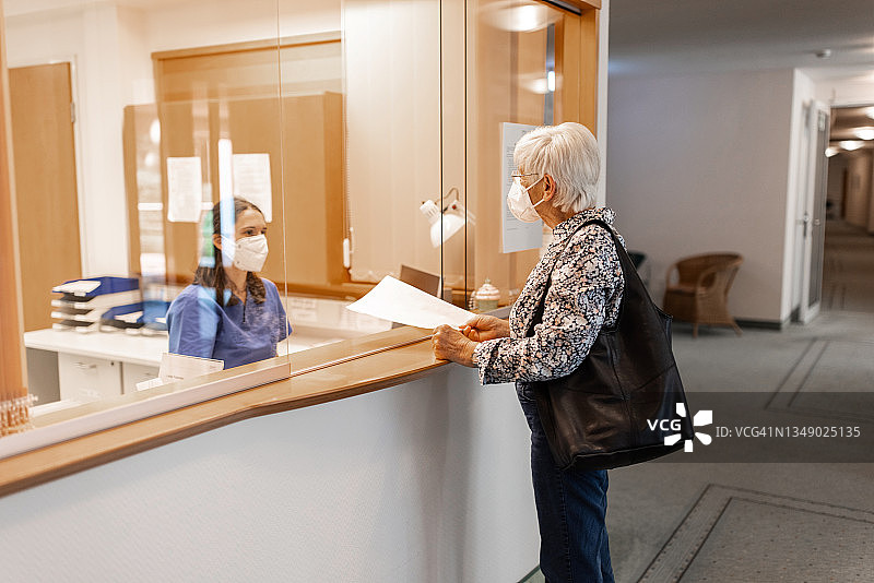 护士在医院接待处帮助老年患者图片素材