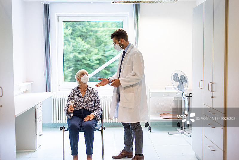 医生在诊所为年长女性进行握力测试图片素材