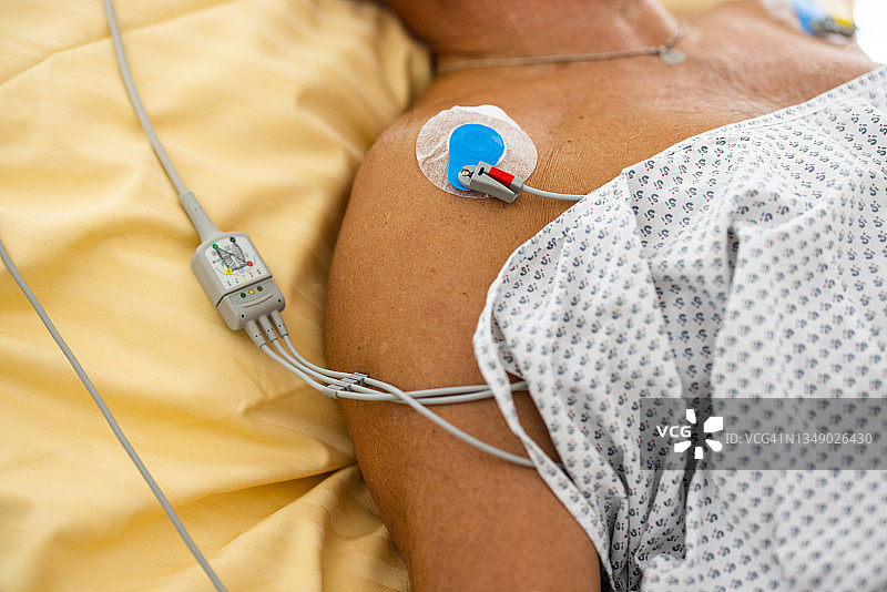 连接心电图机的年长男病人躺在床上图片素材